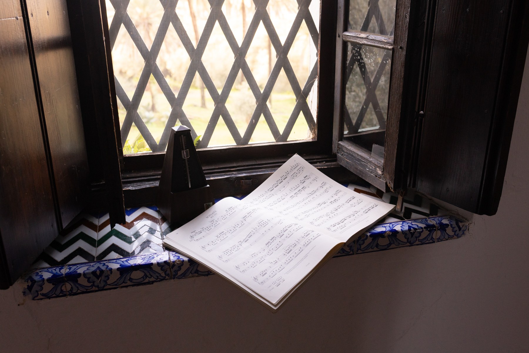 Partitura y metrónomo junto a una ventana